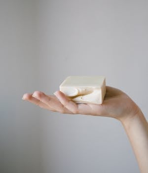 Close-up of a hand delicately holding a premium handcrafted soap bar, showcasing natural skincare.